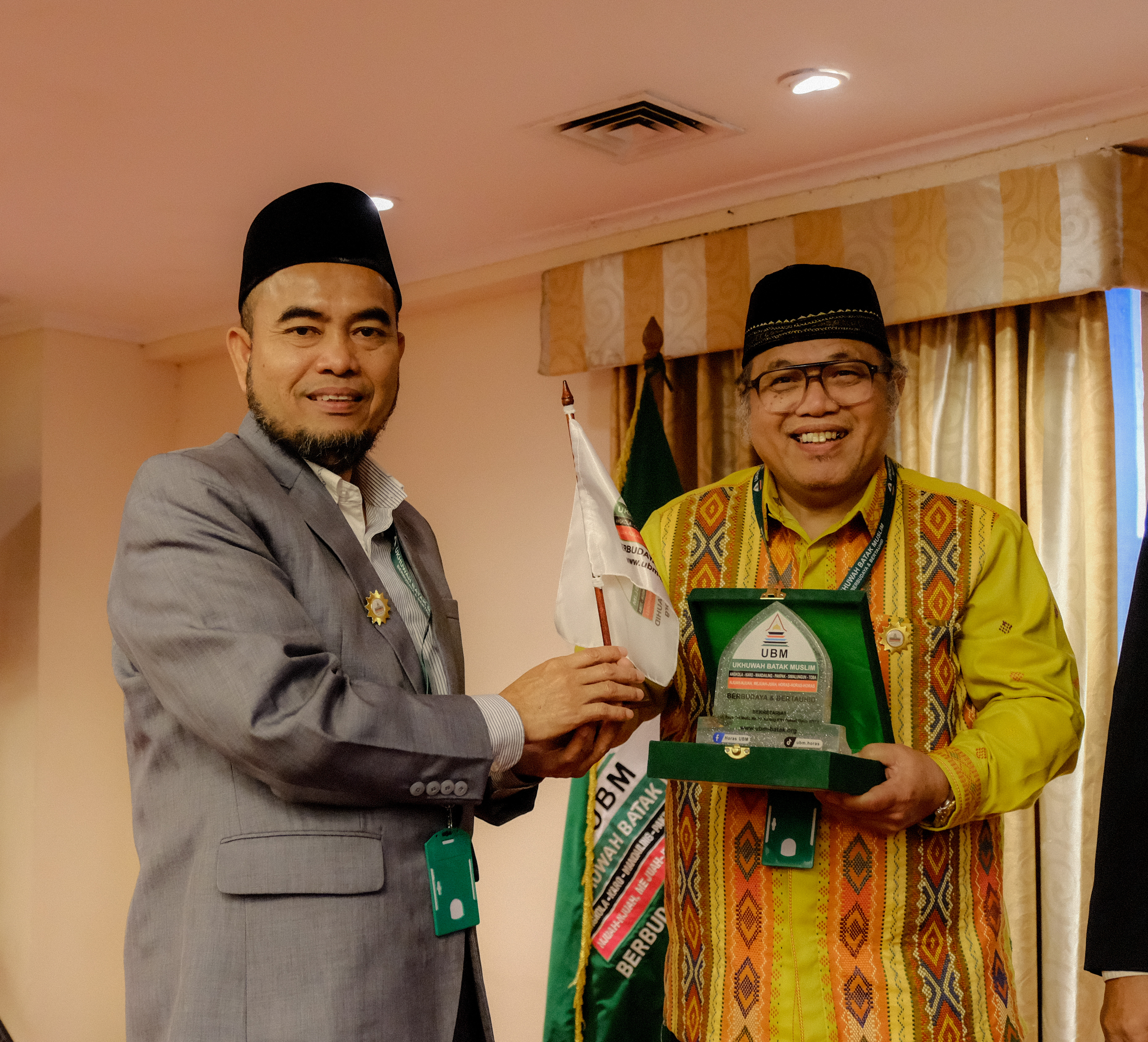 <span  class="uc_style_uc_tiles_grid_image_elementor_uc_items_attribute_title" style="color:#ffffff;">Pemberian cinderamata oleh Dewan Penasehat UBM KH. Syamsul Arifin Nababan</span>
